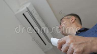 一个戴眼镜的男人，拿着遥控器，打开家里的空调。 分离系统连接到